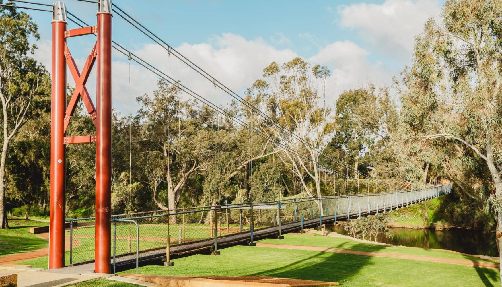 Suspension bridge in Pinjarra, WA, surrounded by lush greenery and tall trees, offering scenic views and outdoor adventure opportunities.